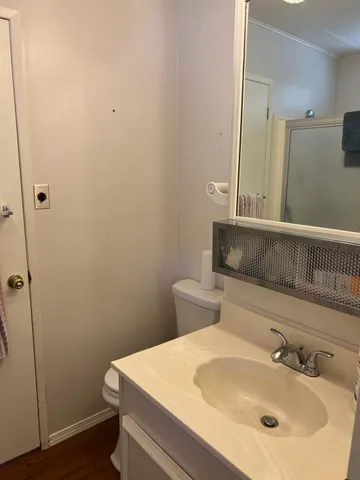 a view of a room with wooden floor and mirror