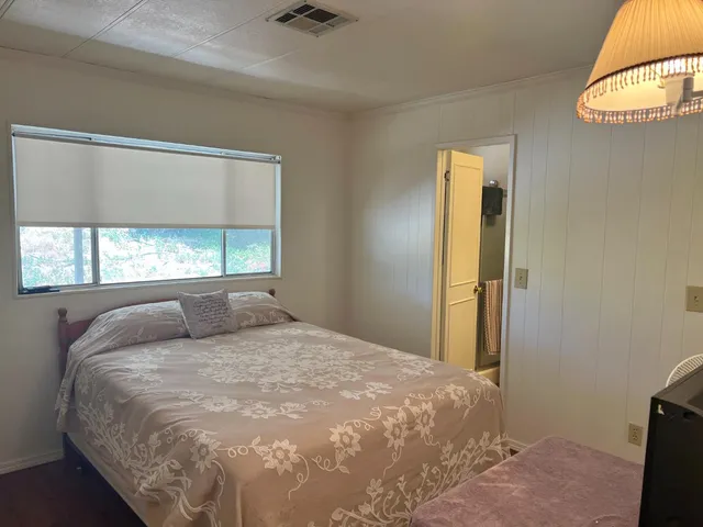 a large bed sitting in a bedroom next to a window
