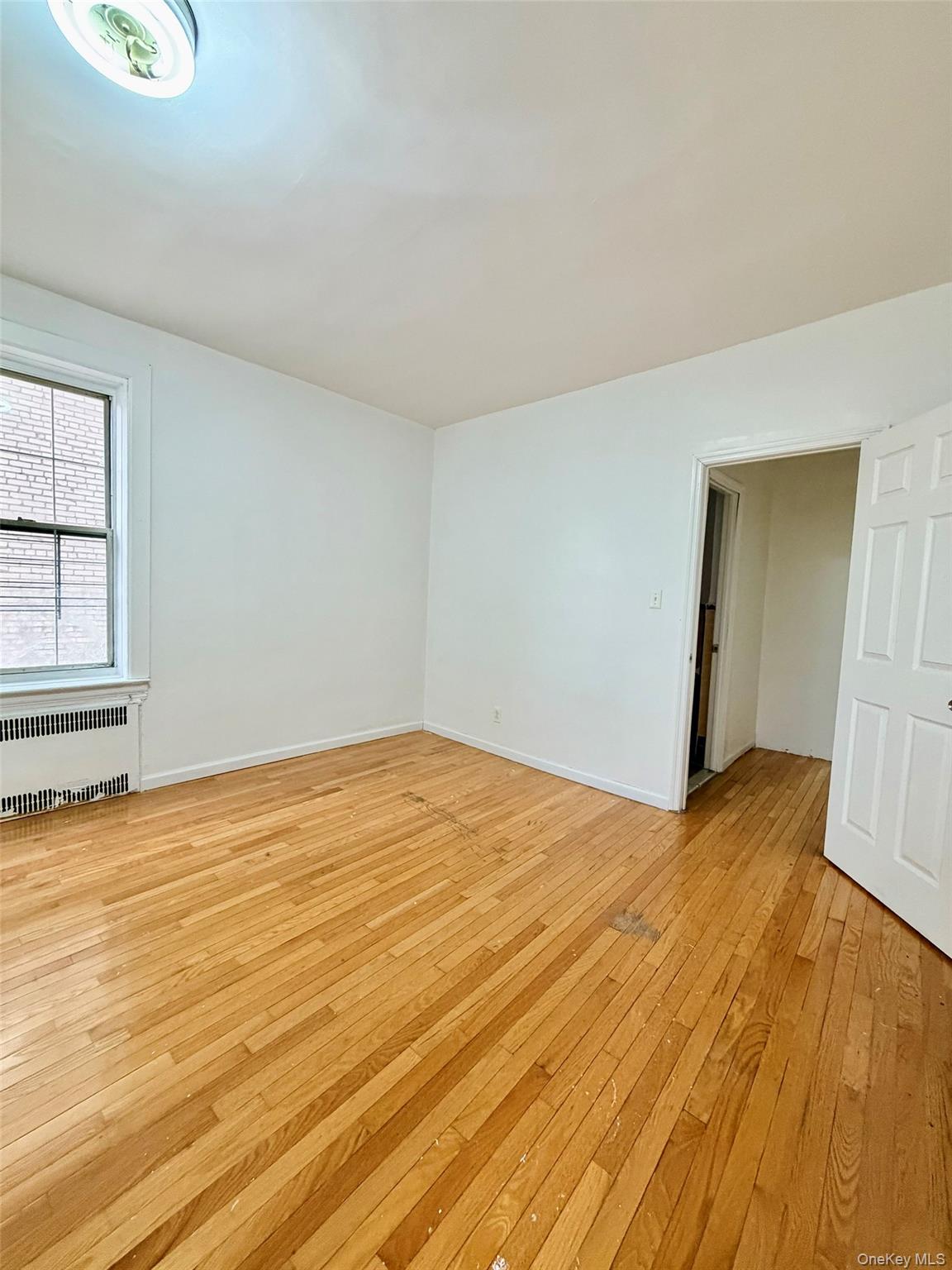 88-11 88th Street, Unit D2 Queens, NY 11373 - Photo 6 of 12 a view of empty room with wooden floor and fan