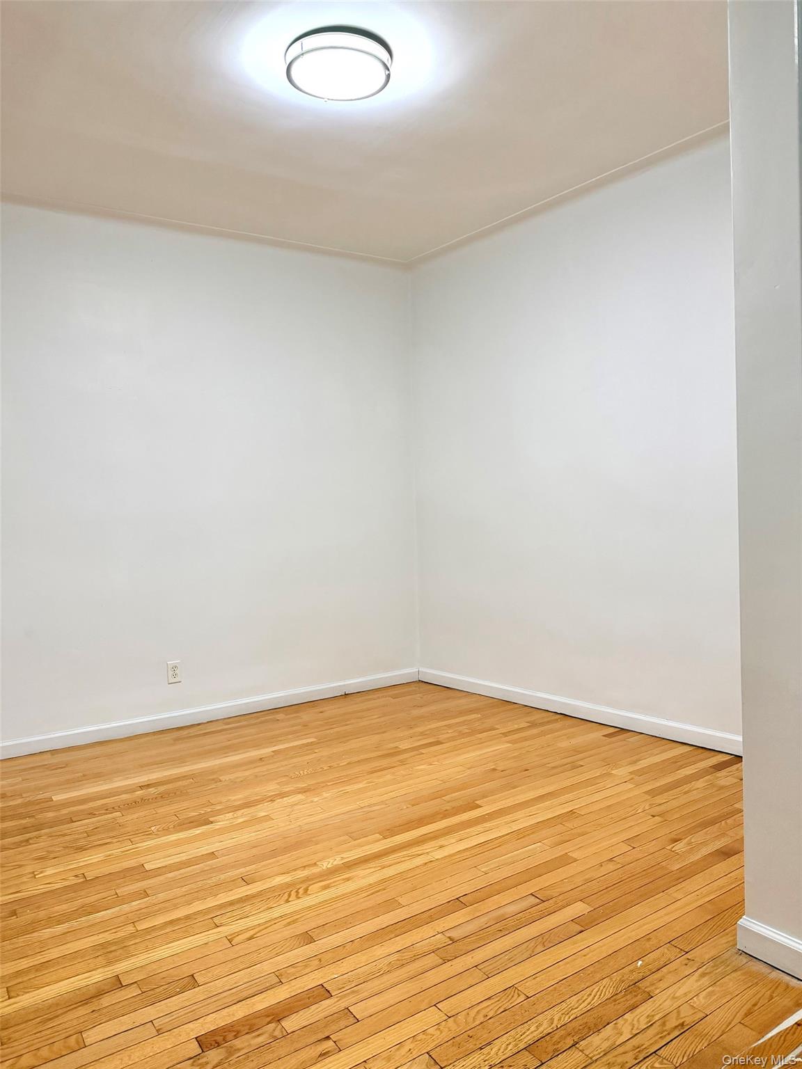 88-11 88th Street, Unit D2 Queens, NY 11373 - Photo 7 of 12 a view of an empty room and wooden floor