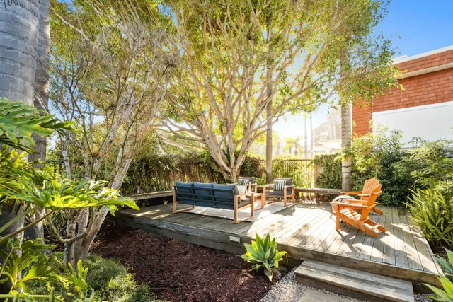 a view of patio with couches table and chairs and potted plants