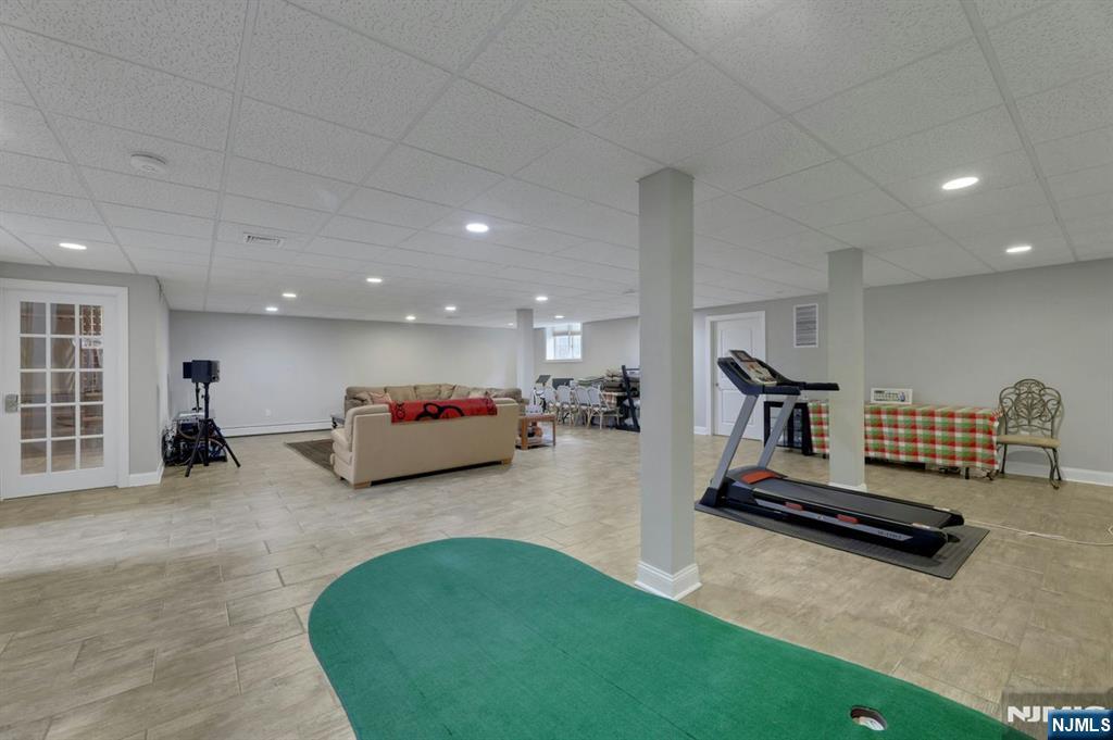 520 Homans Avenue Closter, NJ 07624 - Photo 28 of 34 a living room with furniture gym equipment and a rug