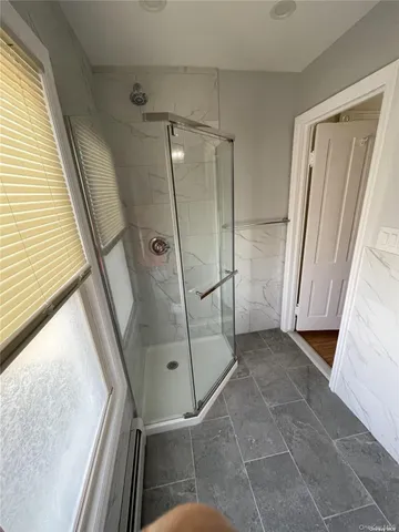 a bathroom with a glass door shower and a sink