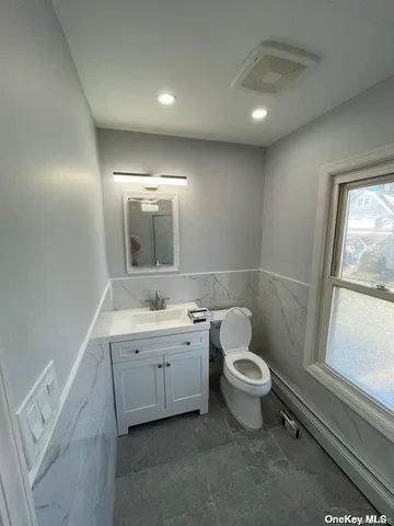a bathroom with a toilet sink and mirror