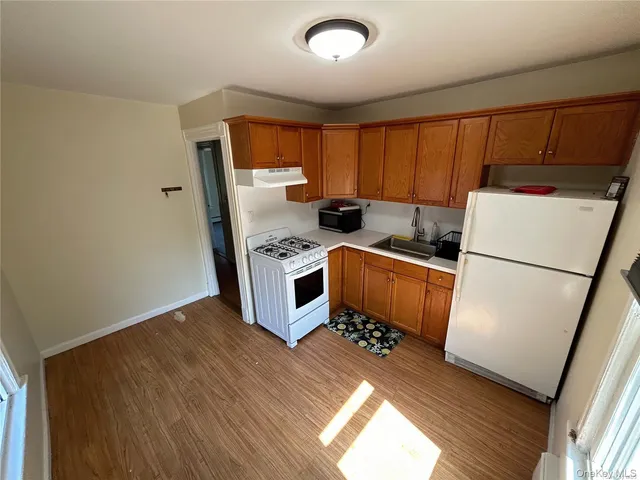 a kitchen with sink a refrigerator and white cabinets