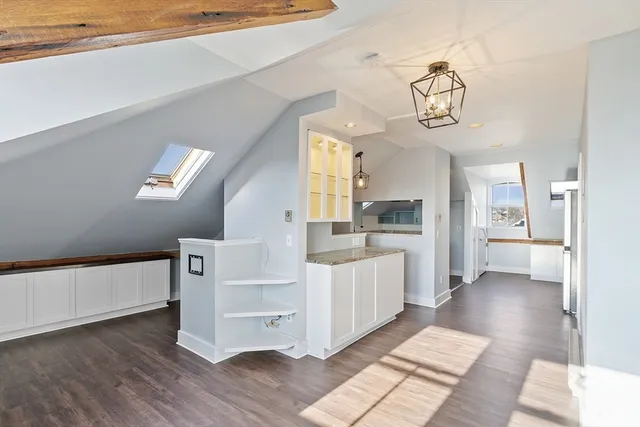 a view of a hallway with wooden floor windows and a kitchen view