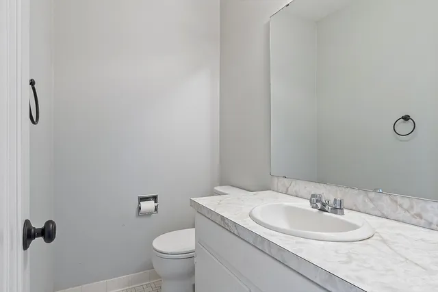 a bathroom with a granite countertop sink a toilet and a mirror