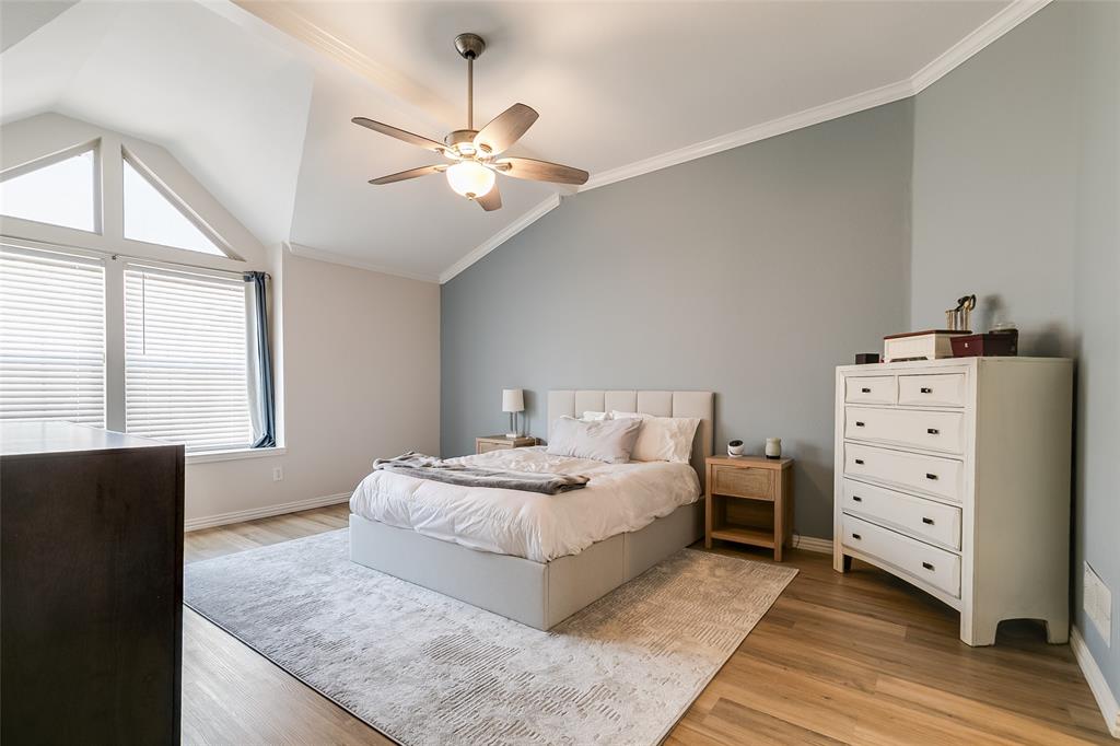 18240 Midway Road, Unit 1004 Dallas, TX 75287 - Photo 14 of 22 a bedroom with a large bed and a chandelier