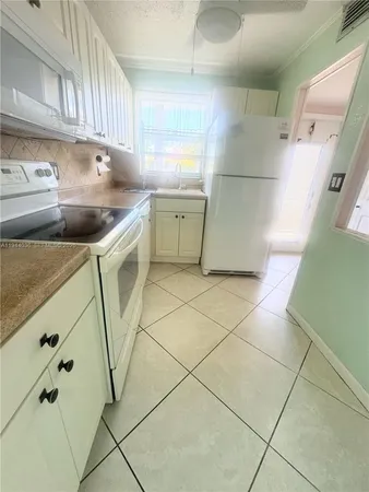 a kitchen with stainless steel appliances a sink a stove a refrigerator and cabinets