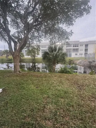 a view of a yard in front of a house with large trees