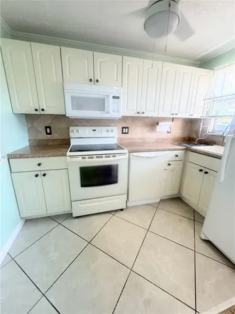 a kitchen with a stove sink and cabinets