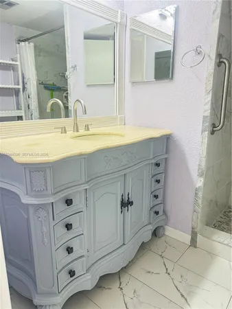 a bathroom with a sink vanity and mirror