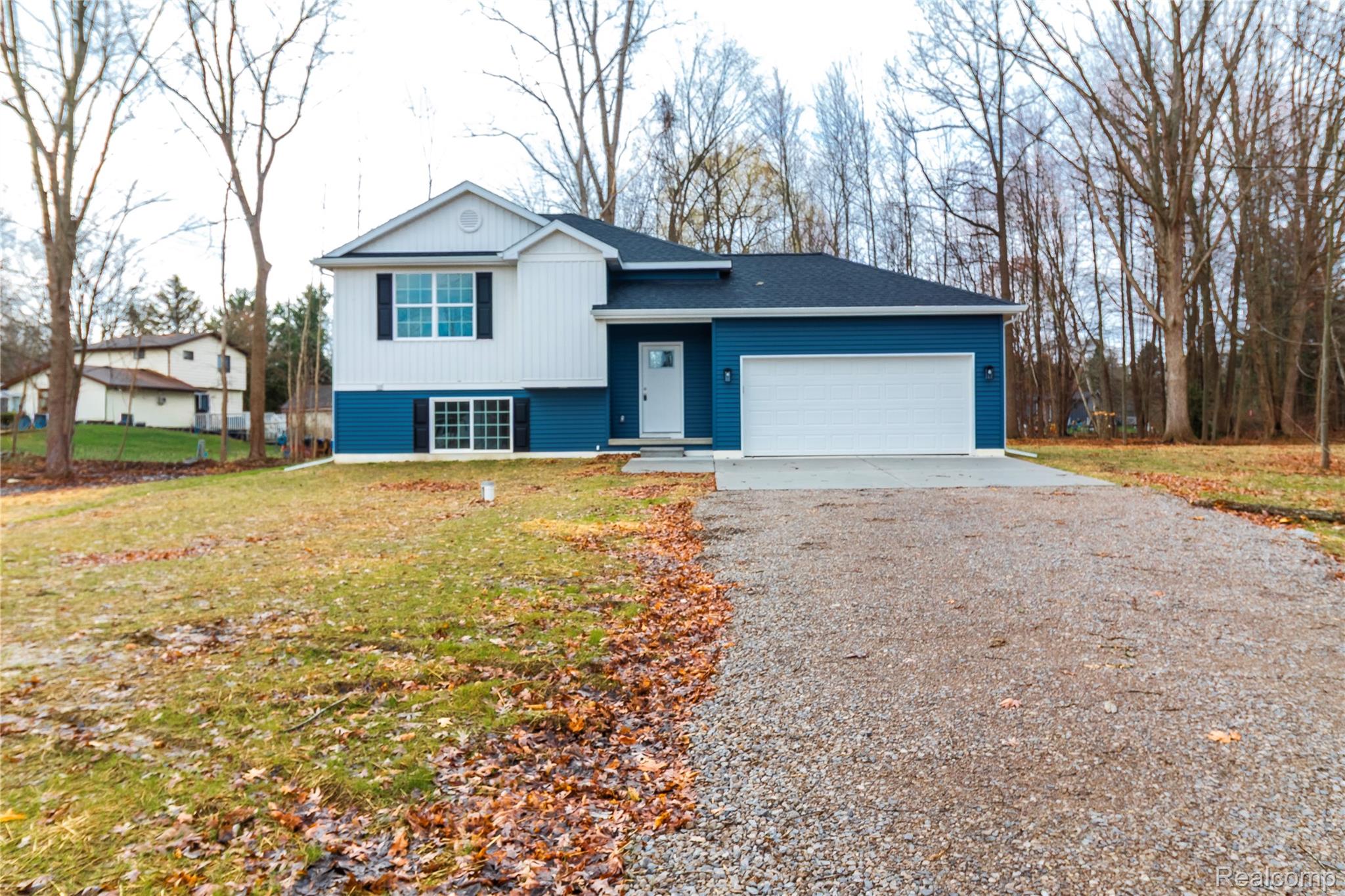 5155 Coldwater Road Lapeer, MI 48446 - Photo 23 of 24 Split level home with gravel driveway, a front lawn, and a garage