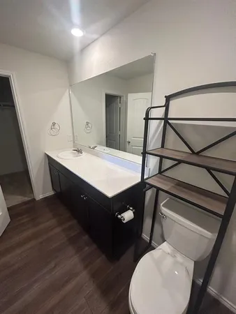 a spacious bathroom with a double vanity sink toilet mirror and bathtub