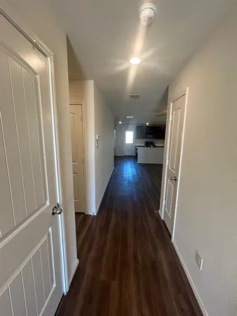 a view of a hallway with wooden floor