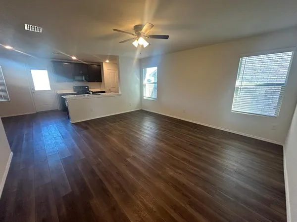 a view of a livingroom with furniture a ceiling fan and wooden floor