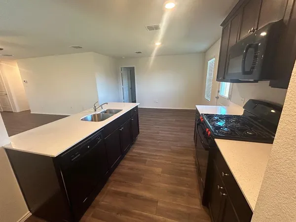 a kitchen with stainless steel appliances wooden cabinets a stove a sink and a refrigerator