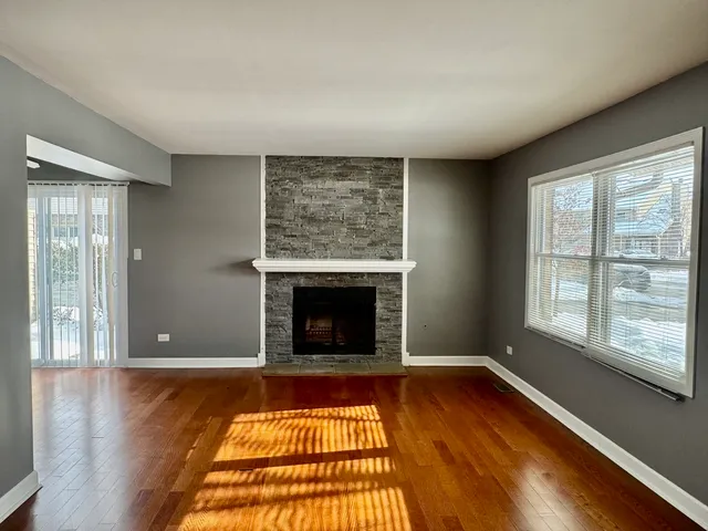 wooden floor fireplace and windows in an empty room