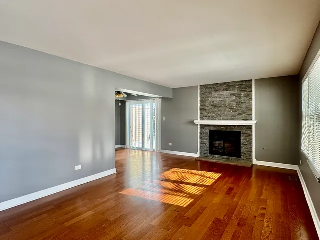 wooden floor fireplace and natural light in room