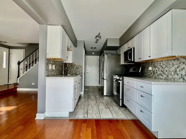 a kitchen with cabinets and wooden floor