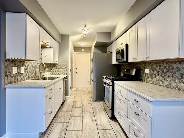 a kitchen with granite countertop a sink stainless steel appliances and cabinets