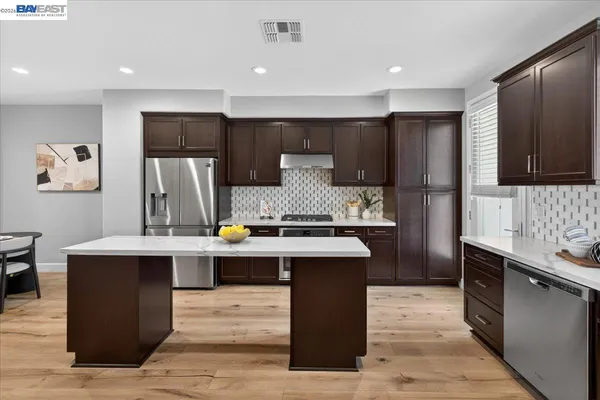 a living room with couches and a dining table with kitchen view