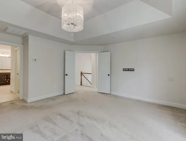 a view of an empty room with chandelier