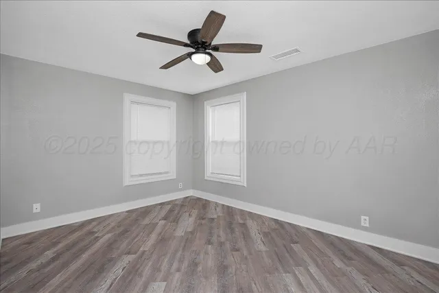 a view of a room with wooden floor and a ceiling fan