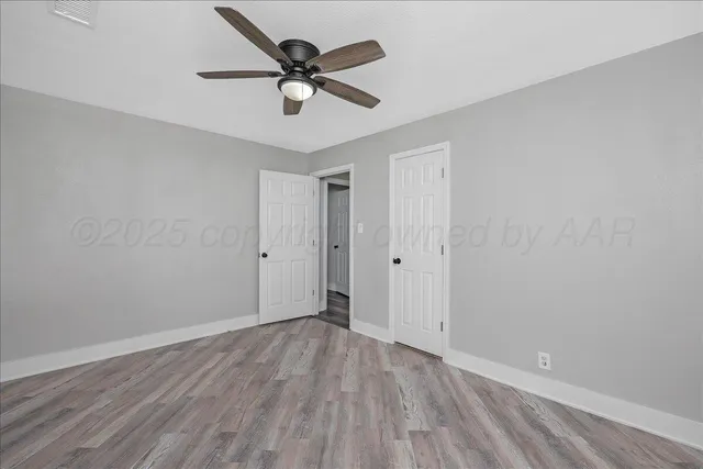 a view of a big room with wooden floor and a ceiling fan