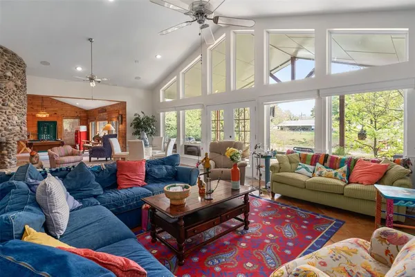 a living room with furniture a large window and a rug