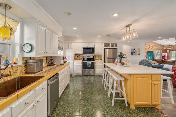 a kitchen with stainless steel appliances kitchen island granite countertop a sink and cabinets