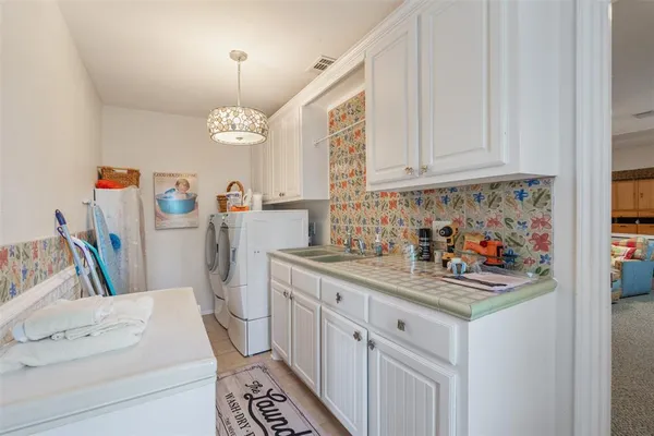a kitchen with stainless steel appliances a white cabinets counter space and a window
