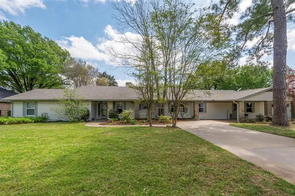 a backyard of a house with yard table and chairs