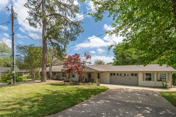 a view of a big house with a big yard and large trees
