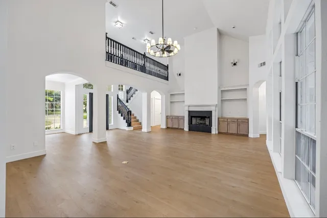 a view of a livingroom with a fireplace a chandelier and entryway