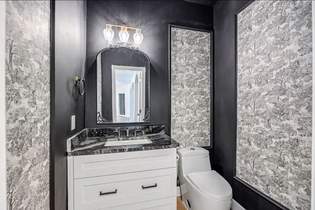 a bathroom with a toilet sink and mirror
