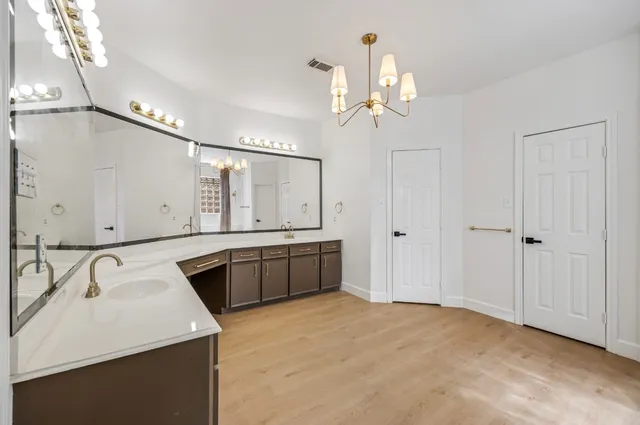 a spacious bathroom with a sink a vanity a mirror and a shower