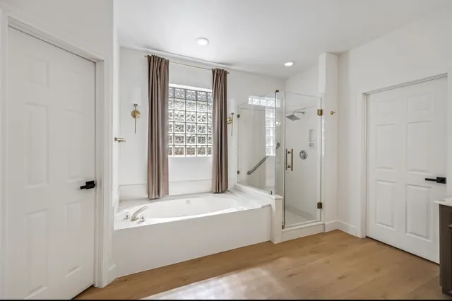 a bathroom with a tub shower and sink