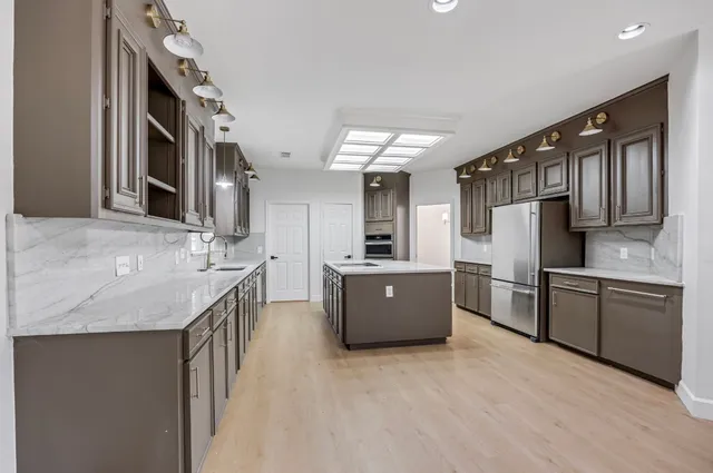 a kitchen with stainless steel appliances granite countertop a sink stove and refrigerator