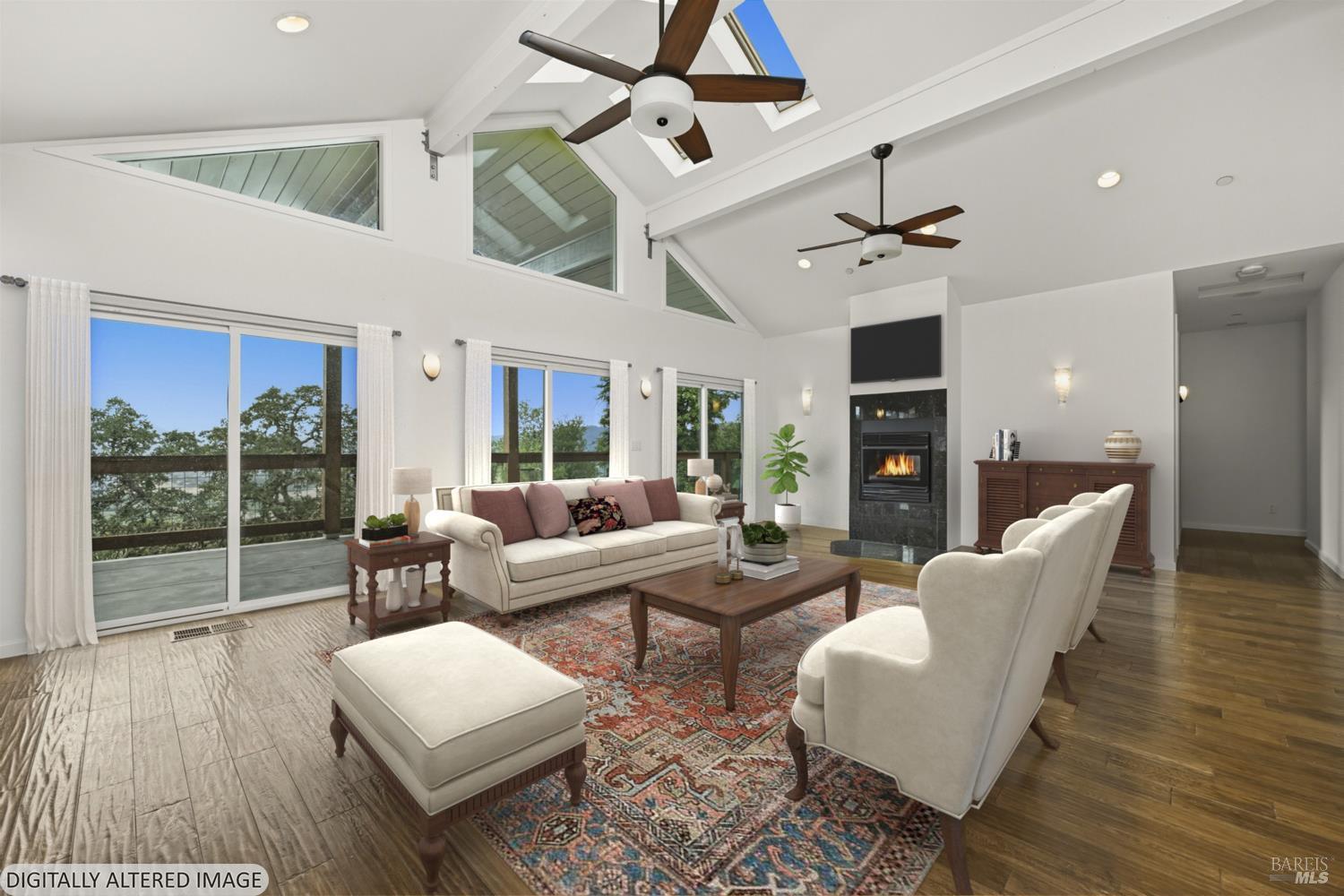 31000 Pine Mountain Road Cloverdale, CA 95425 - Photo 19 of 61 The open living room centers around a fireplace and walls of glass framing the surrounding hills and valley below. Virtually staged to illustrate the scale and design potential of the vaulted living room with expansive windows and valley views.