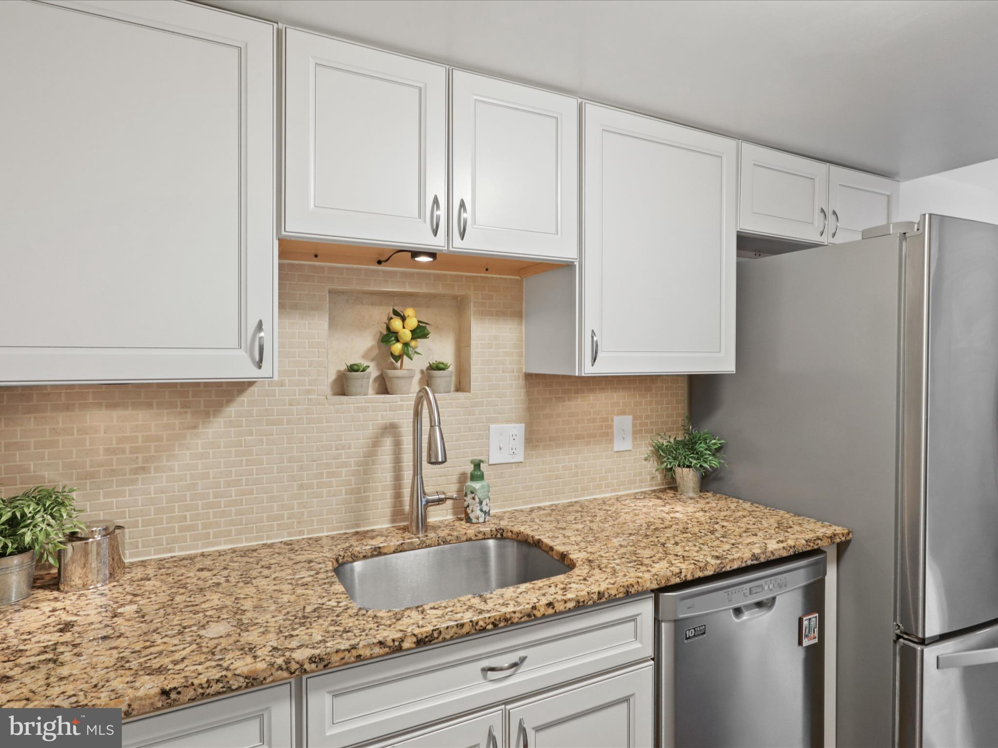 6558 Gildar Street Alexandria, VA 22310 - Photo 11 of 53 a kitchen with granite countertop a sink a stove and cabinets