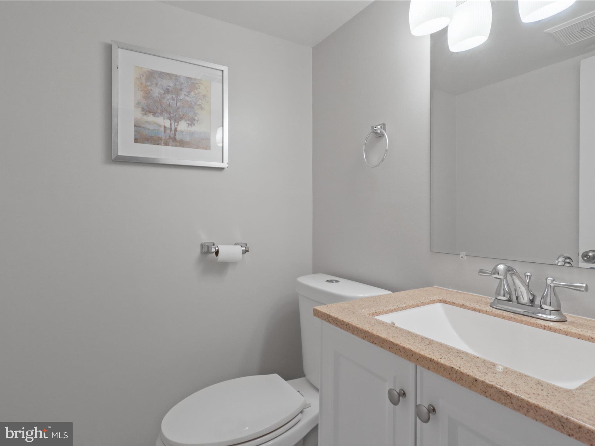 6558 Gildar Street Alexandria, VA 22310 - Photo 21 of 53 a bathroom with a granite countertop toilet a sink and mirror