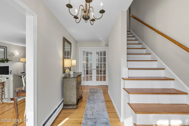 a view of a hallway with wooden floor and staircase