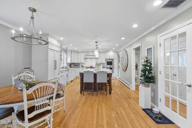 a dining room with furniture a chandelier and wooden floor