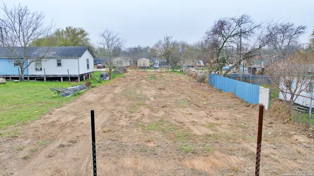 a backyard of a house with table and chairs