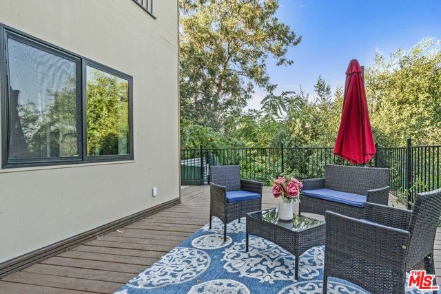 a view of a patio with table and chairs potted plants with wooden floor and fence
