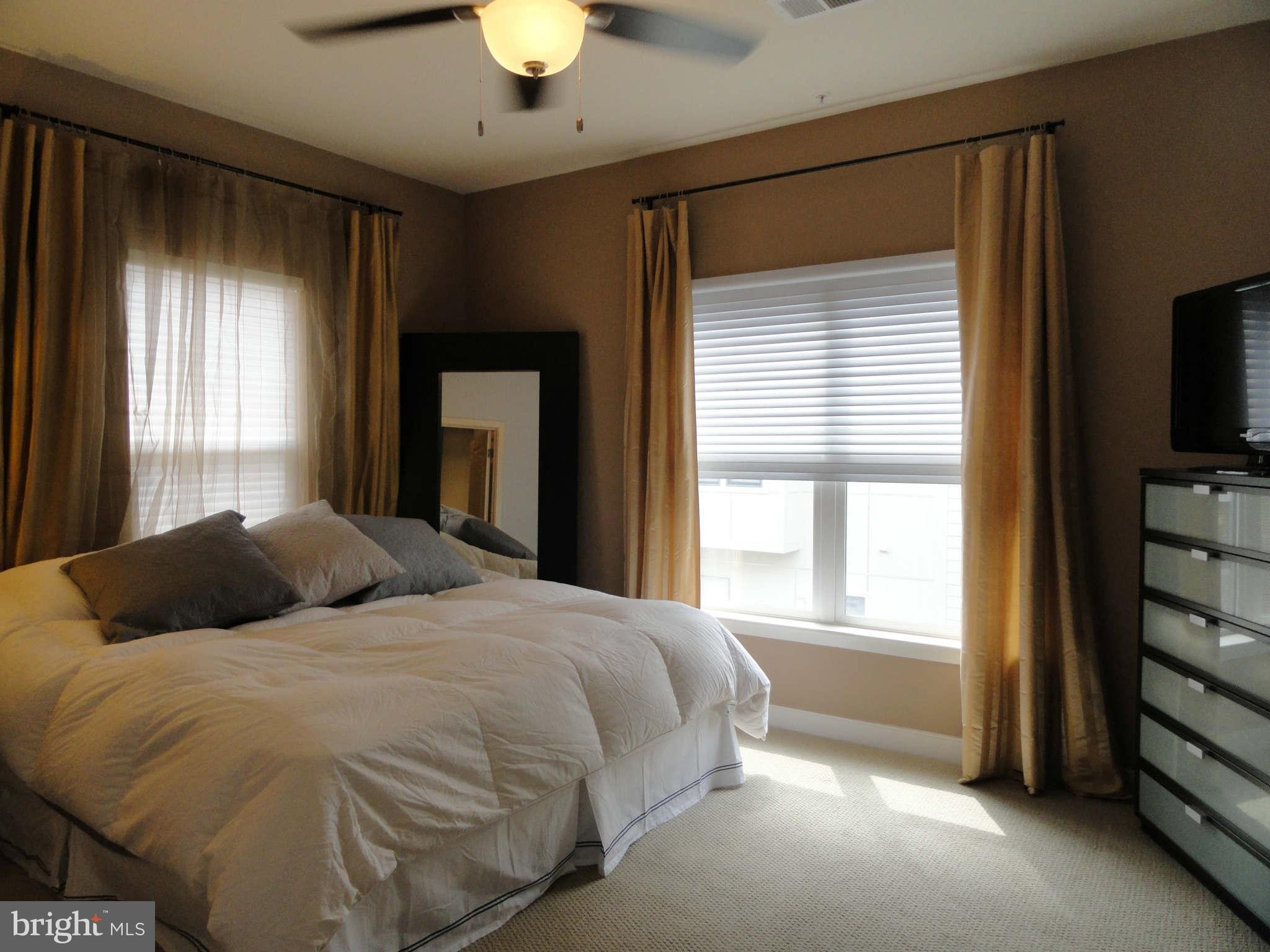 4159 Legato Road Fairfax, VA 22033 - Photo 12 of 25 a bedroom with a bed and a flat tv screen next to a window