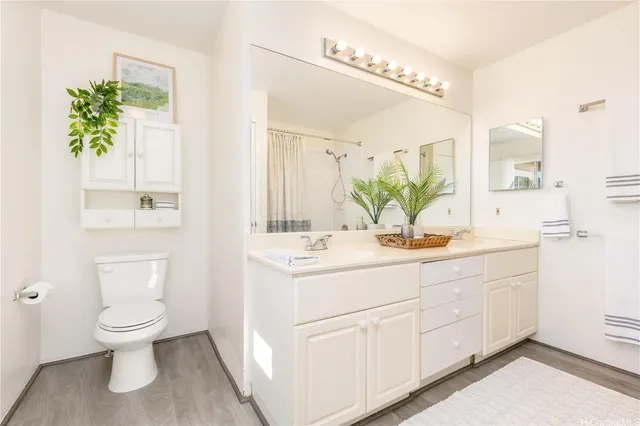 a bathroom with a sink a toilet and a mirror