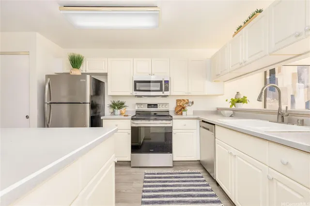 a kitchen with a sink cabinets and stainless steel appliances