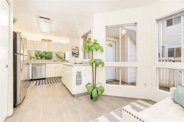 a white bed sitting in a room next to a window